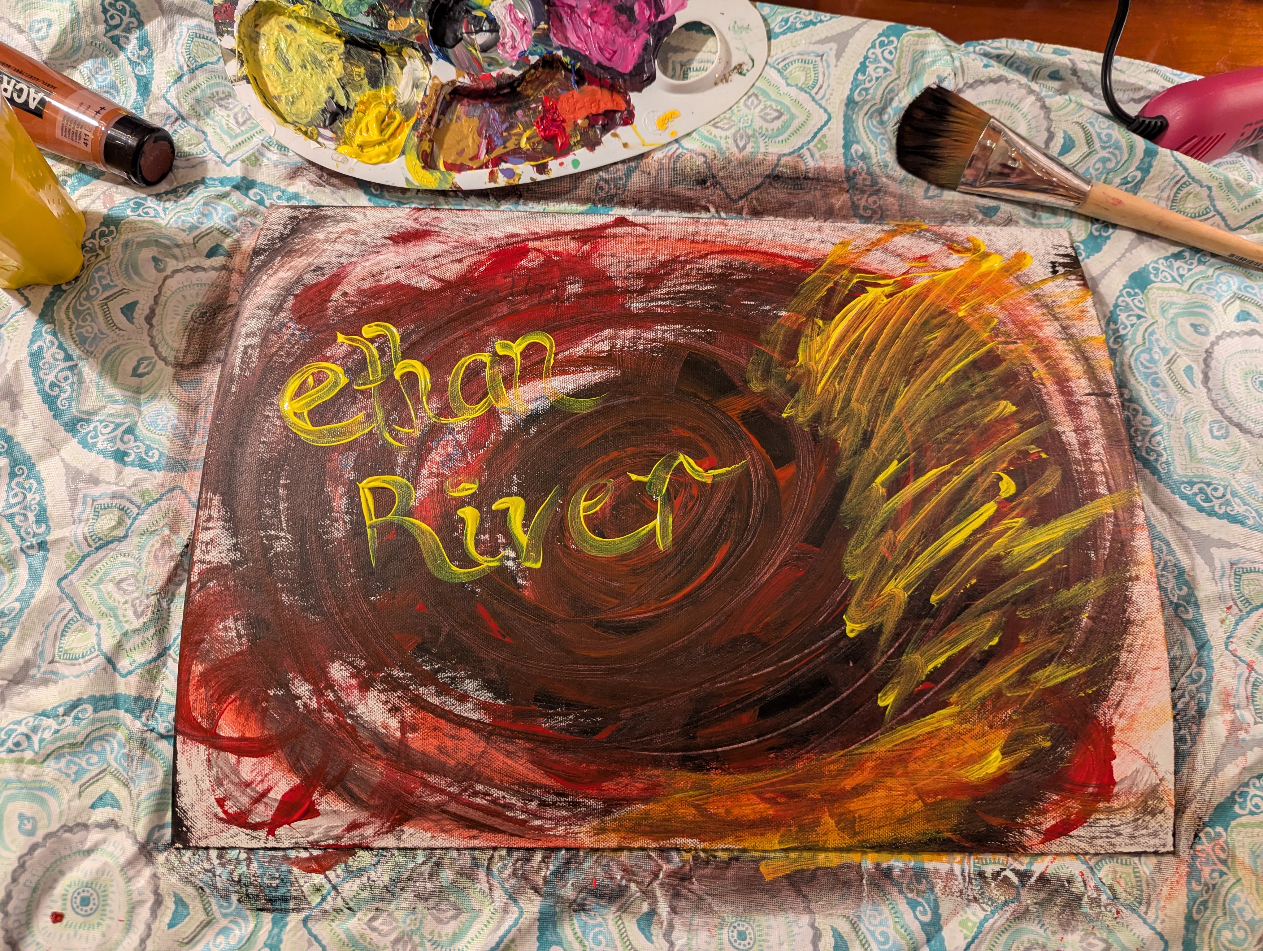 An early state of Verdalisse: yellow words and sweeping red marks, with paints and brushes still around the canvas